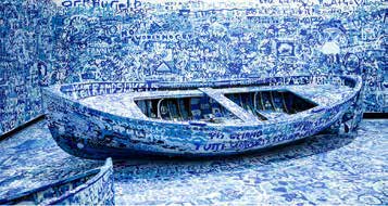 Installation d’un bateau peint en bleu et couvert de messages manuscrits