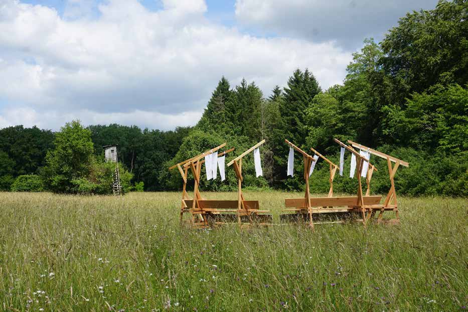 Une structure en bois et des tissus suspendus dans une prairie de la vallée de la Schwalb